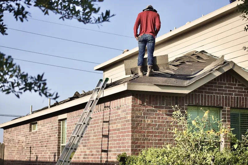 Professional roofer working on a residential roof in Centerport